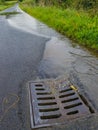 Water on flooded road and going down a drain Royalty Free Stock Photo