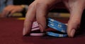 Cards and chips on the table in a casino. Close-up of hands.. Close-up of hands playing poker with chips on red table. Royalty Free Stock Photo