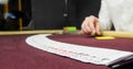 Cards and chips on the table in a casino. Close-up of hands.. Close-up of hands playing poker with chips on red table. Royalty Free Stock Photo