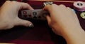 Cards and chips on the table in a casino. Close-up of hands.. Close-up of hands playing poker with chips on red table. Royalty Free Stock Photo