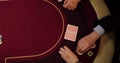 Cards and chips on the table in a casino. Close-up of hands.. Close-up of hands playing poker with chips on red table. Royalty Free Stock Photo