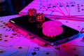 Cards, phone, casino chips and dice close up. Computer keyboard and smartphone, illuminated with pink light. Concept of Royalty Free Stock Photo