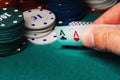 Cards with one pair of aces in the game of poker in the hands of a gambler on the background of chips Royalty Free Stock Photo