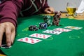 Poker chips with playing cards on a green table