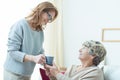 Care assistant helping elderly lady