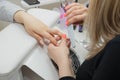 Woman in a nail salon receiving a manicure by a beautician