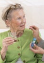 Care giver or nurse giving to elderly woman her pills Royalty Free Stock Photo