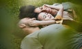 Care, happy and a family lying on the grass in nature for bonding, laughing and comfort. Love, smile and an interracial Royalty Free Stock Photo