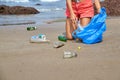 Woman busy collecting rubbish, holds garbage bag