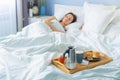 Happy young woman lying and sleep at the bed with breakfast on tray Royalty Free Stock Photo