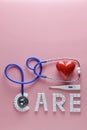 CARE word made from medicine pills and stethoscope, temperature, red heart on pink background. Copy space, Concept of Valentine`s Royalty Free Stock Photo