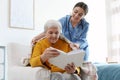 Care worker covering elderly woman with plaid in hospice