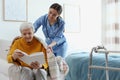 Care worker covering elderly woman with plaid in hospice Royalty Free Stock Photo