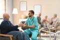 Care worker giving water to woman in geriatric hospice Royalty Free Stock Photo