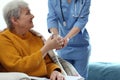 Care worker giving water to elderly woman in hospice Royalty Free Stock Photo