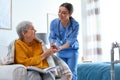 Care worker giving water to elderly woman in hospice Royalty Free Stock Photo