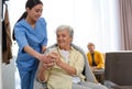 Care worker giving water to woman in geriatric hospice Royalty Free Stock Photo