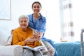 Care worker giving water to elderly woman in hospice Royalty Free Stock Photo