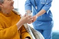 Care worker giving water to elderly woman in geriatric hospice Royalty Free Stock Photo