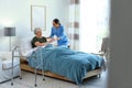 Care worker giving water to elderly woman in hospice Royalty Free Stock Photo
