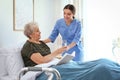 Care worker giving water to elderly woman in hospice Royalty Free Stock Photo