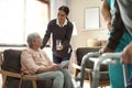 Care worker giving water to elderly woman with tablet in hospice Royalty Free Stock Photo