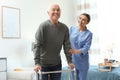 Care worker helping elderly man with walker in hospice Royalty Free Stock Photo