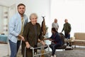 Care worker helping to elderly woman with walker in hospice Royalty Free Stock Photo