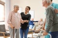 Care workers helping to elderly patients to walk in hospice