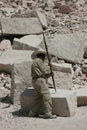 A career cillar that is working at a large white stone brick with a metal bar