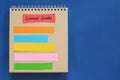 Career goals concept. Checklist of goals in note pad in blue background with copy space. Royalty Free Stock Photo