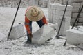 A career sillar that is lifting up a large brick made of soft stone