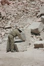 A career sillar that is working and looking at the measurements of a large white stone brick in Arequipa, Peru