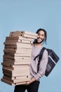 Carefree arab deliveryman carrying big pizza boxes pile