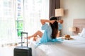 Carefree Asian traveler woman relax on bed in hotel room. Travel alone, summer , holiday concept. Copy space Royalty Free Stock Photo