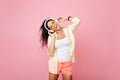 Carefree asian woman in summer clothes singing favorite song with happy face expression. Indoor portrait of fascinating