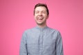 Carefree attractive guy in blue shirt showing tongue and making funny face Royalty Free Stock Photo