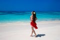 Carefree beautiful woman enjoying on the exotic sea. Happy brunette girl in red dress relax on tropical beach island. Summer Royalty Free Stock Photo