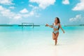Carefree bikini Woman on tropical beach. Pretty slim girl with coctail enjoying on exotic island in turquoise ocean. Brunette