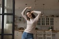 Carefree cheerful millennial dancer girl having fun at home