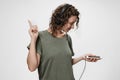 Carefree cheerful young curly woman listen favourite playlist in music app