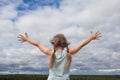 Carefree child girl against skyline sky clouds outdoor