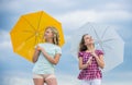 Carefree children outdoors. Girls friends with umbrellas cloudy sky background. Freedom and freshness. Weather forecast