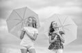 Carefree children outdoors. Girls friends with umbrellas cloudy sky background. Freedom and freshness. Weather forecast