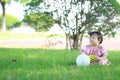 Carefree Chinese baby girl play a ball and balloon on the lawn