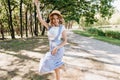 Carefree european girl in blue attire dancing in park. Outdoor portrait of blithesome young woman i