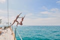 Carefree excited young women jumping from boat to swim in the ocean. Two friends on a holiday cruise together jumping Royalty Free Stock Photo