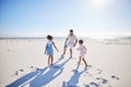 Carefree father and two children playing soccer on the beach. Single dad having fun and kicking ball with his little Royalty Free Stock Photo