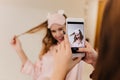 Carefree girl in eyemask playing with her hair for photo. Indoor portrait of dark-haired woman with black manicure using Royalty Free Stock Photo