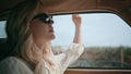 Carefree girl riding automobile putting hand in open window closeup. Driving car